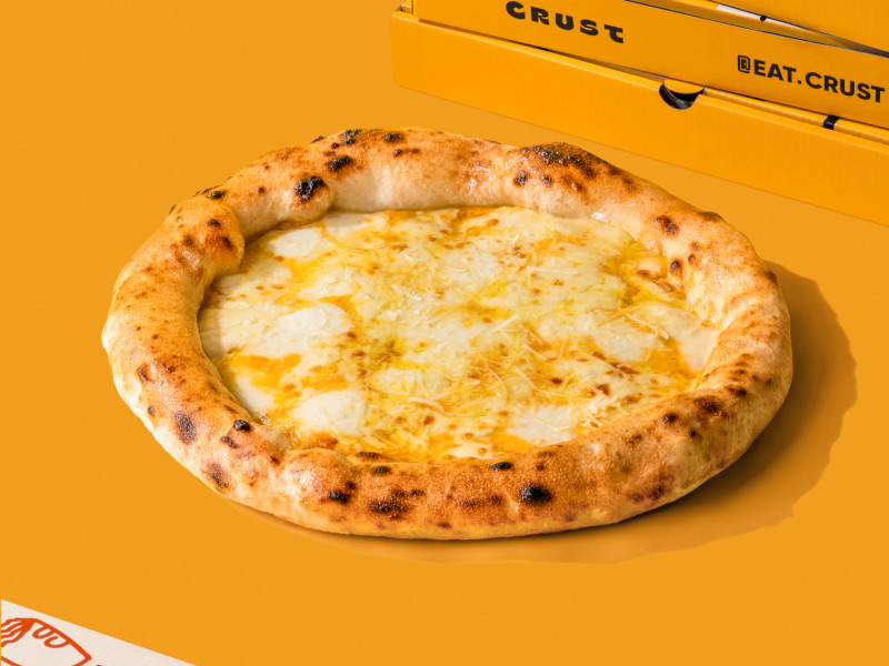 Cheese pizza against a bright yellow background