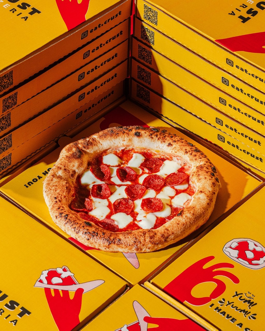 Pepperoni pizza surrounded by Eat Crust boxes